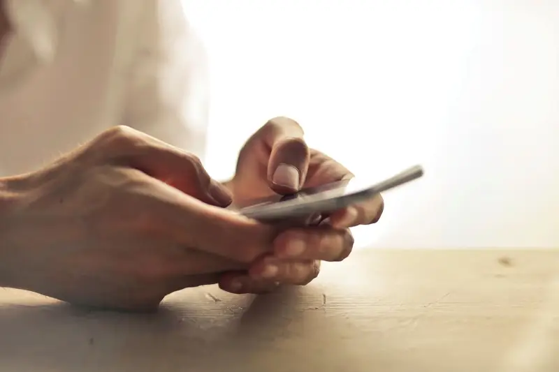 Manos usando un teléfono móvil para hacer el check-in online