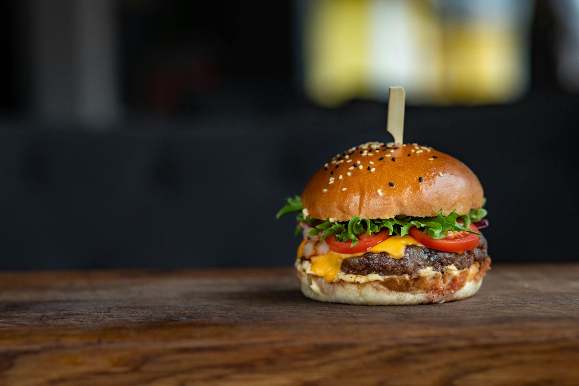 Un primer plano de una hamburguesa en una mesa de madera.